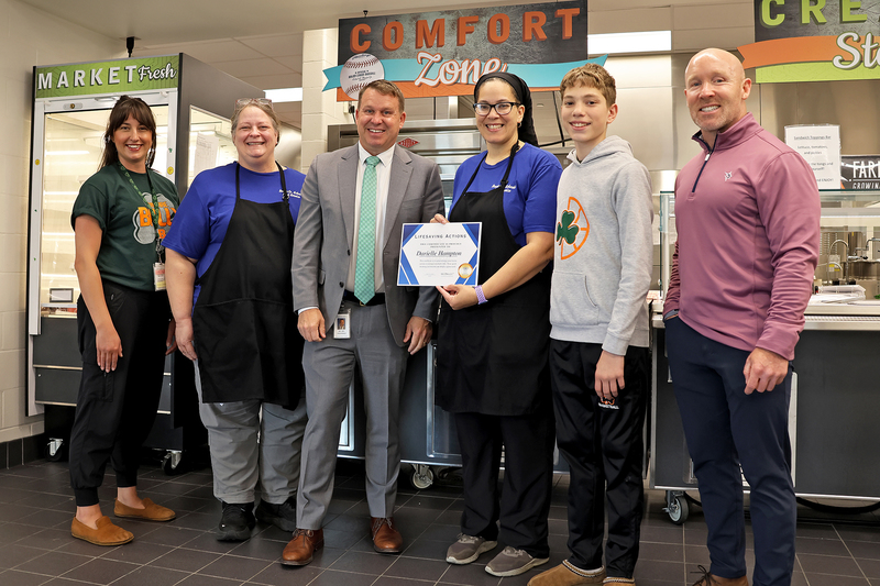 Five adults and a studet with a certificate