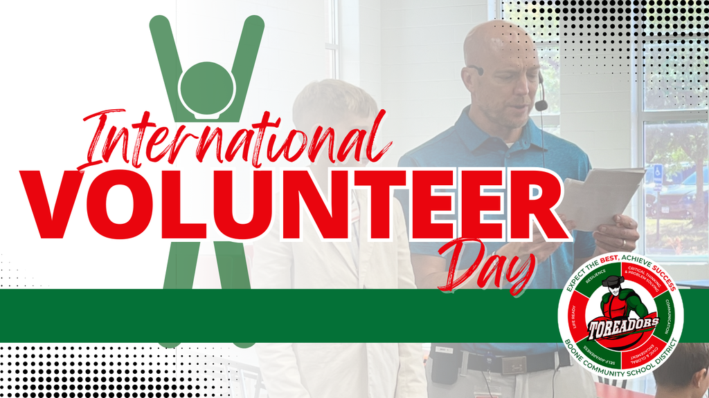 Graphic for International Volunteer Day featuring large red and white text over a faint background of a man reading from a paper. A green stick-figure icon with raised arms appears behind the word ‘International.’ The Boone Community School District Toreadors logo is in the bottom right corner.