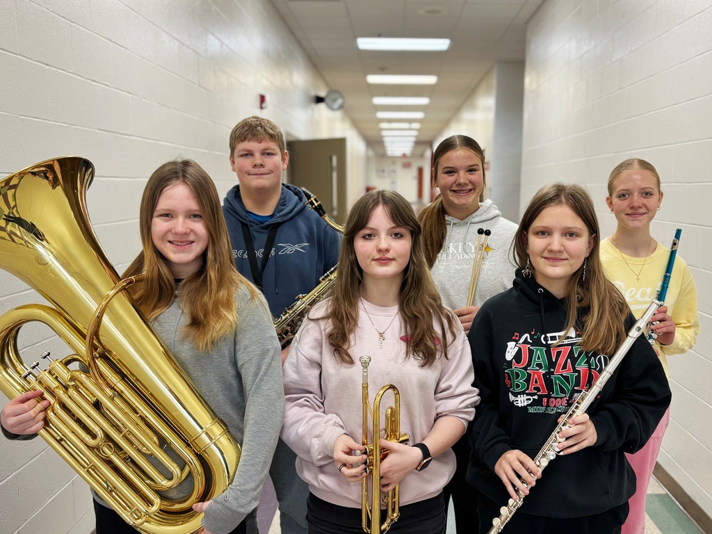 8th grade honor band students holding their instruments