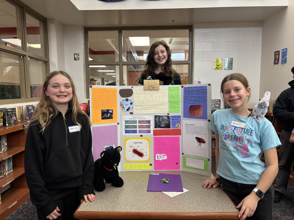 three 6th grade Excel students standing in front of their research project board