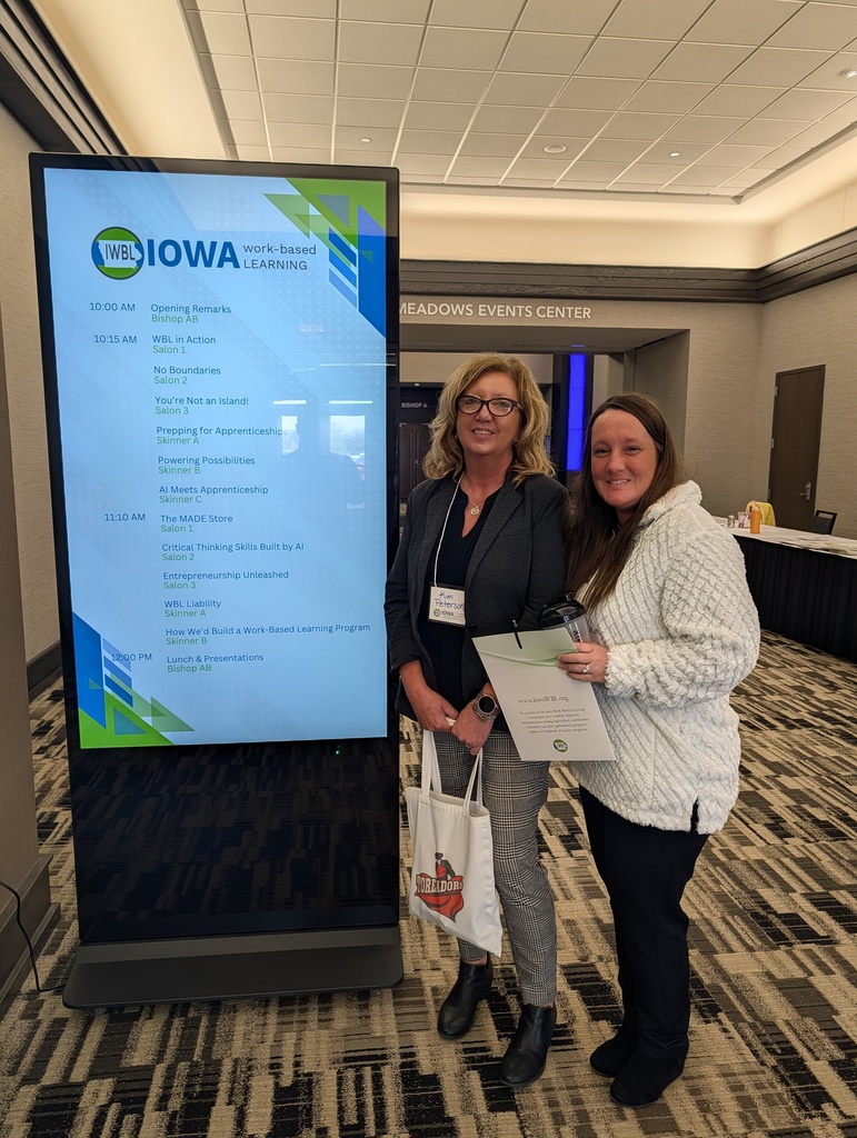 Boone EDGE instructors standing by the work based learning conference digital sign