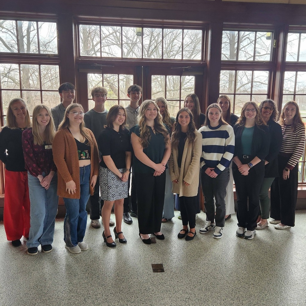 Group of students in the Rising Leaders Academy standing in front of large glass windows