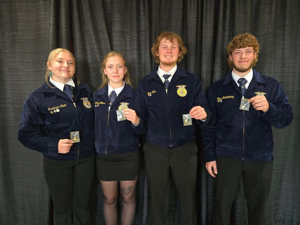 Four students in blue FFA jacket holding award for their Iowa FFA degrees.
