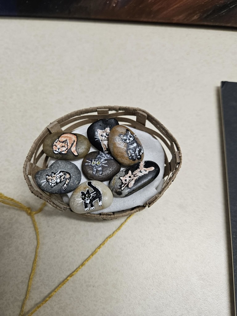 Basket of rocks with an art painting on each rock.