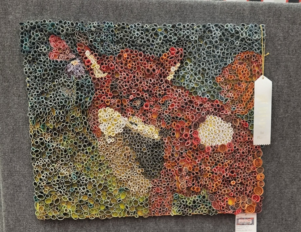 A dimensional art piece of a fox made from rolled up pieces of paper.