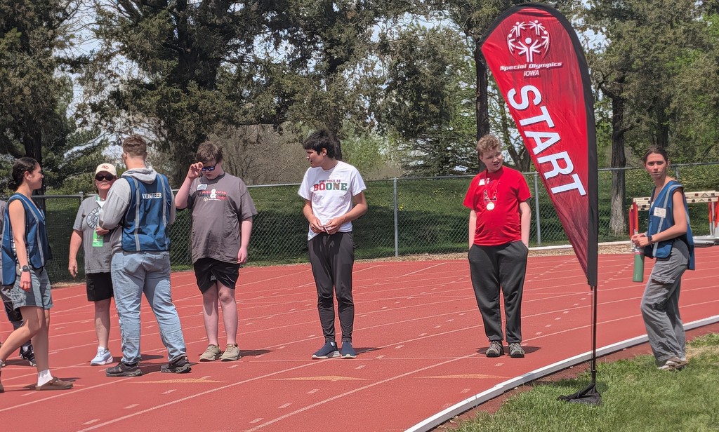 Students standing in a line at the starting line getting ready to run a race.