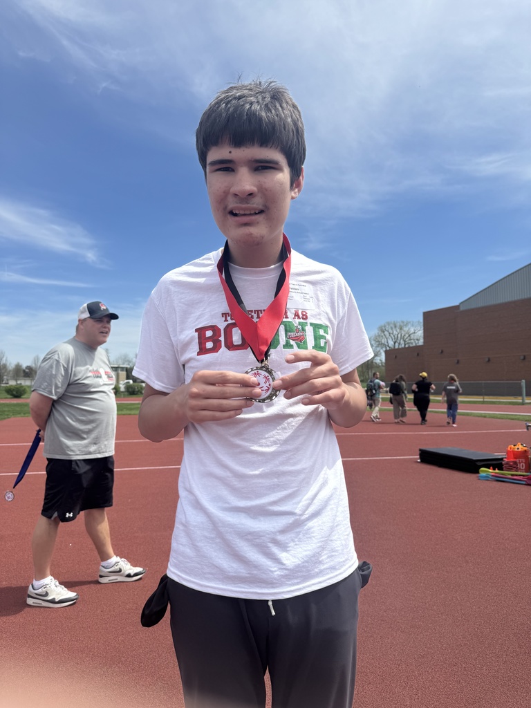 Boone student standing on a running track with a medal around neck.