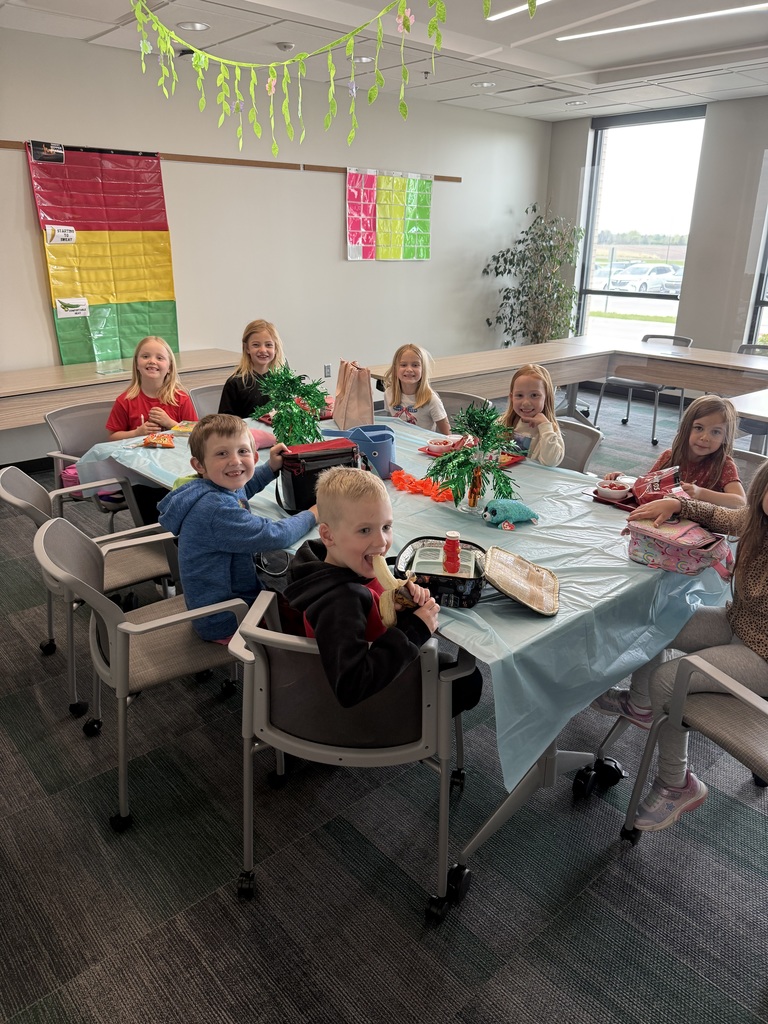 Seven students sitting around a table enjoying lunch.