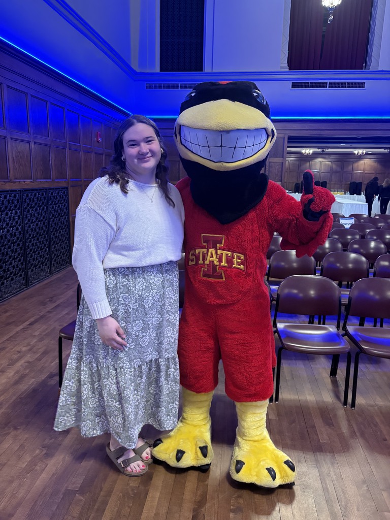 High school student standing with Cy, Iowa State University's mascot.
