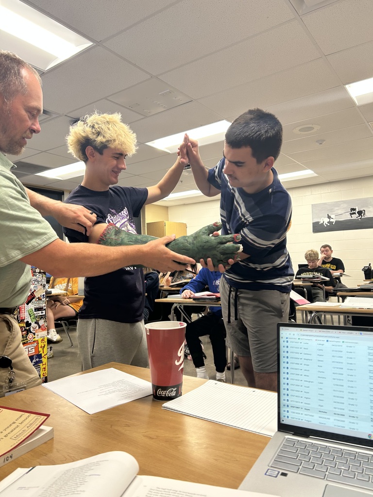 Beowulf snatches at Grendel in Herot