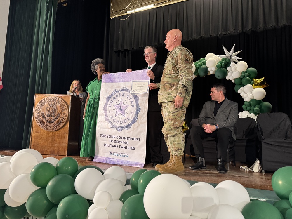 Bossier High principal accepts Purple Star school banner on stage 