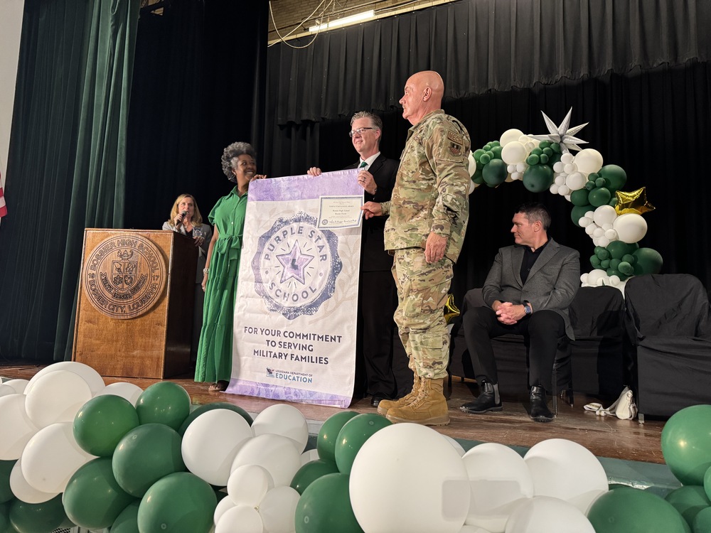 Bossier High principal accepts Purple Star school banner on stage 