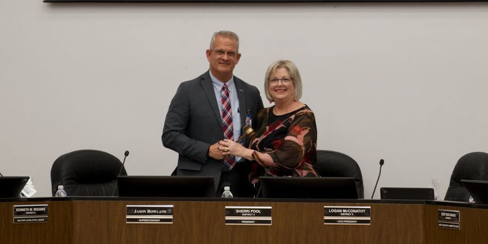 Superintendent is pictured handing the gavel to incoming President Sherri Pool