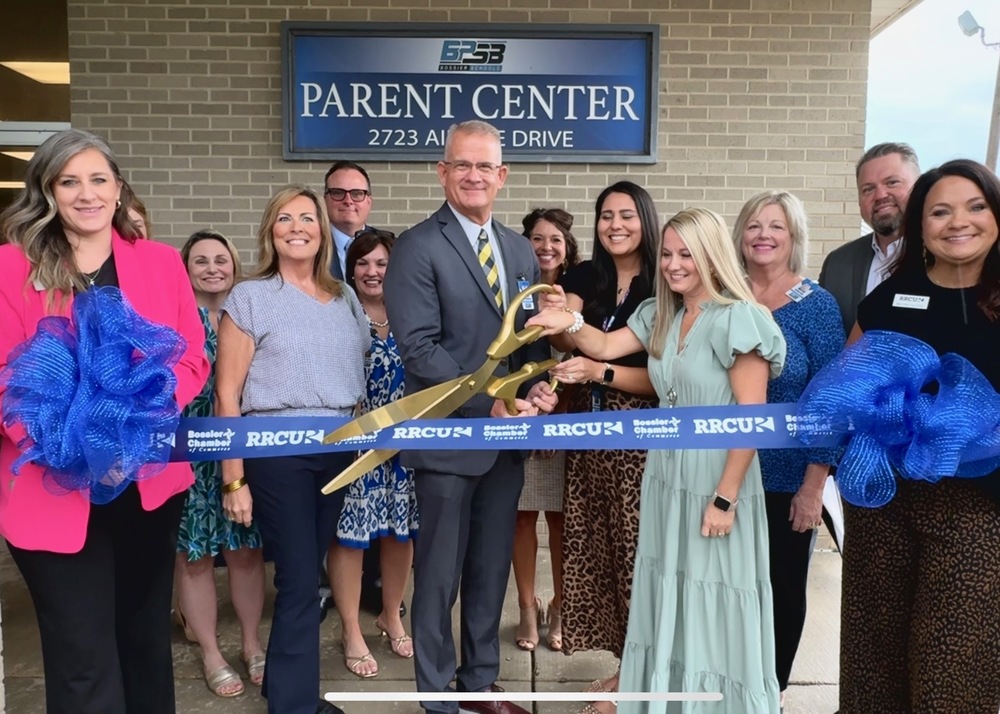 Group of school and Chamber dignitaries cut the ribbon in front of the Parent Center