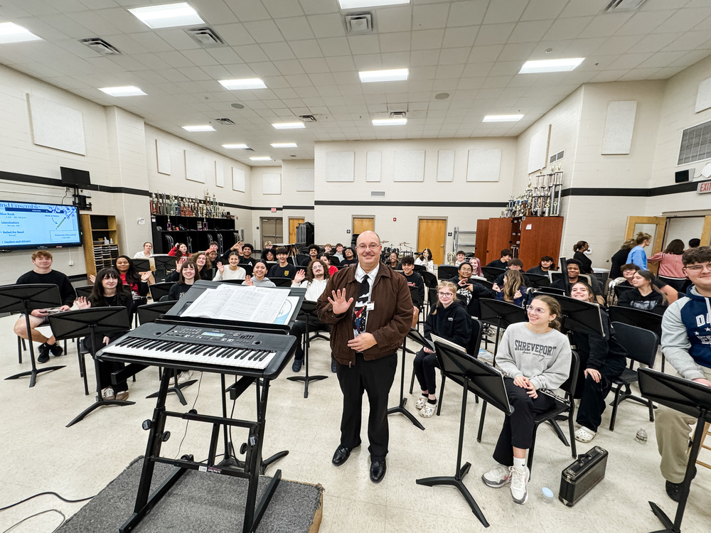Photo of Parkway Band Director Mark Minton surrounded by band students