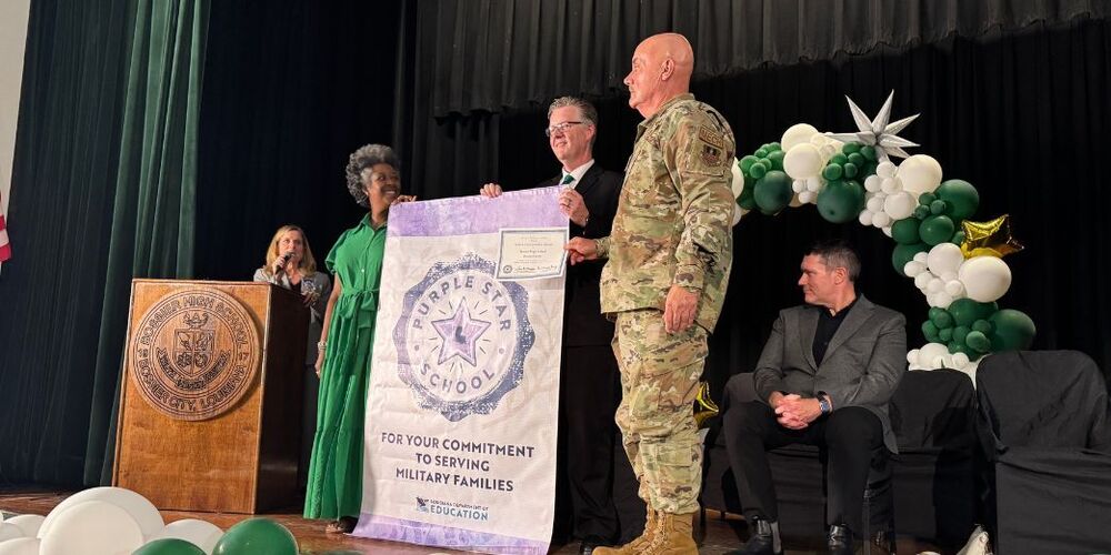 Dr. Billy Neil accepts the Purple Star Banner for Bossier High School