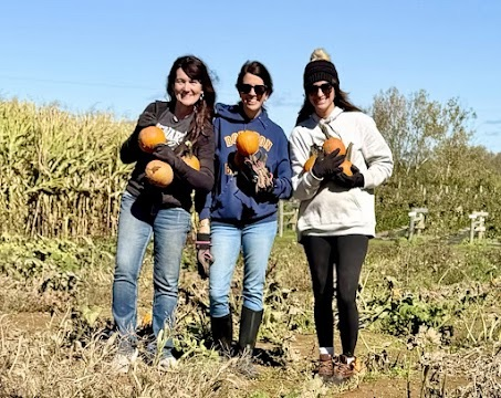 picture of Mrs. Thompson, Mrs. Muntz, and Mrs. Hurter picking pumpkins