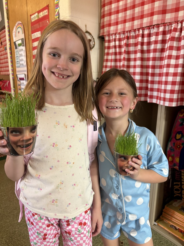 2 female students with their cups of grass