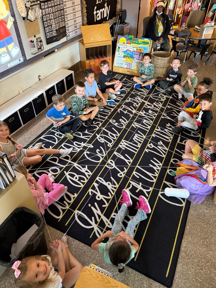 students on the carpet holding the talking string for their Socratic Seminar 