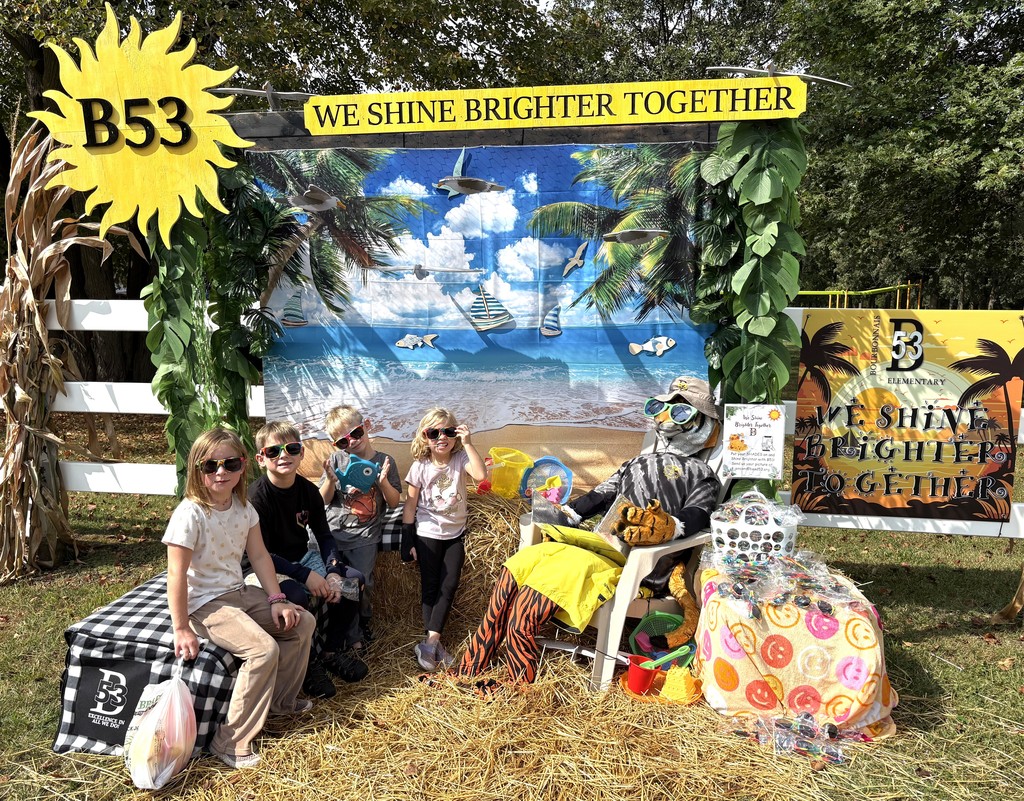 4 students wearing sunglasses at the tiger scarecrow