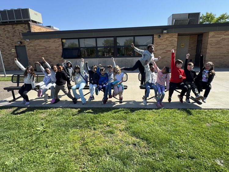 students sitting on outside benches cheering