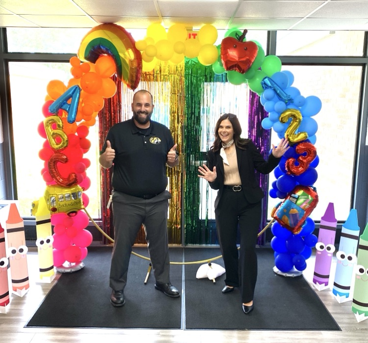 principal and dean under the rainbow balloon arch