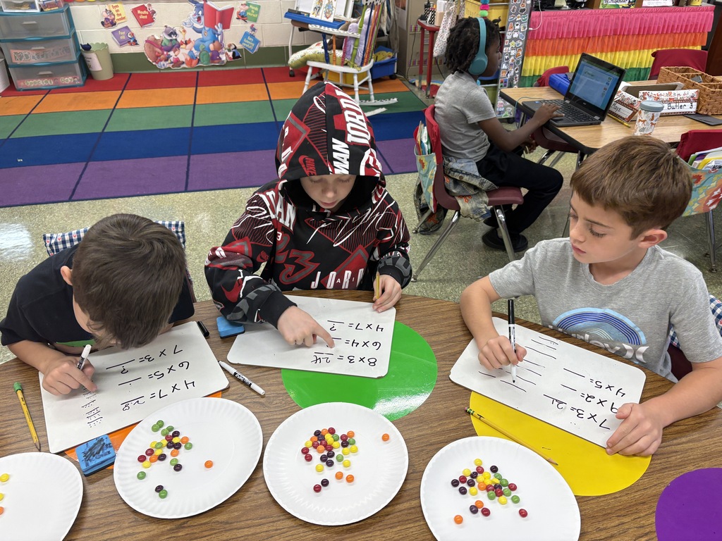 3 male students working with Skittles at the table