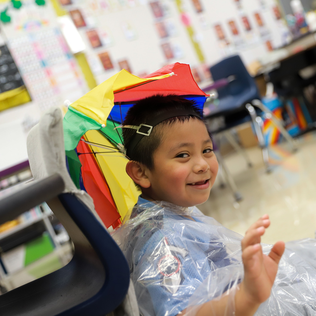 Umbrella hat and poncho, waving at the camera