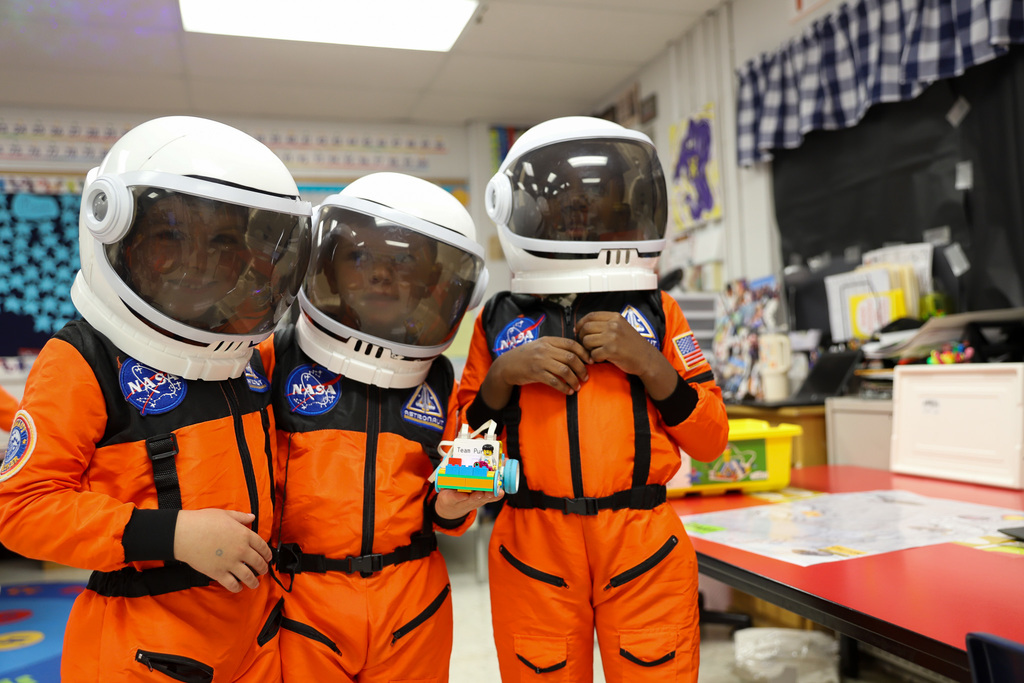 Three kindergarten astronauts with their robot
