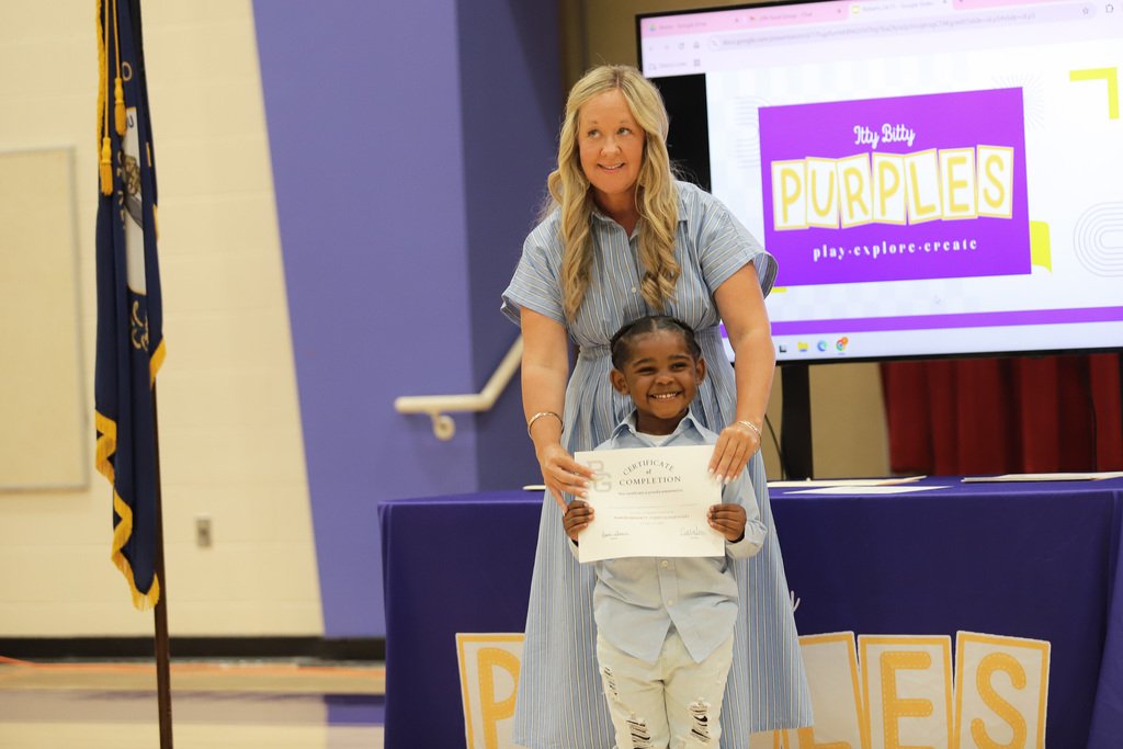 Student smiling at camera with certificate