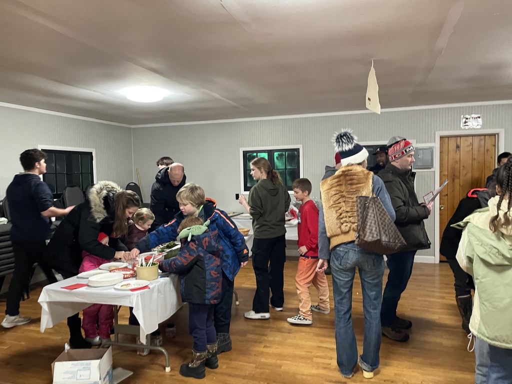 families participate in Christmas activities including cookie decoration