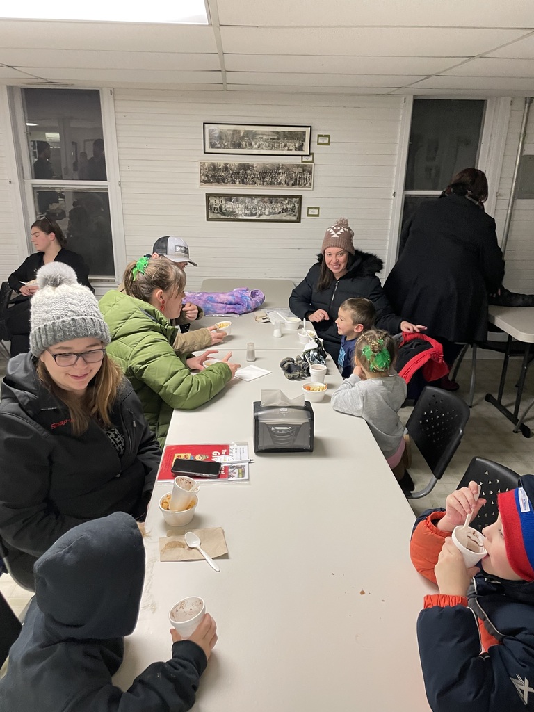 families sit at tables, socialize, and drink hot chocolate