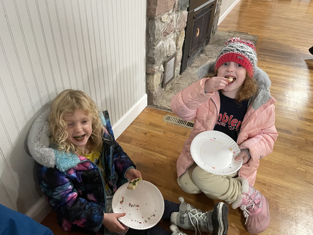 two preschoolers eat Christmas cookies