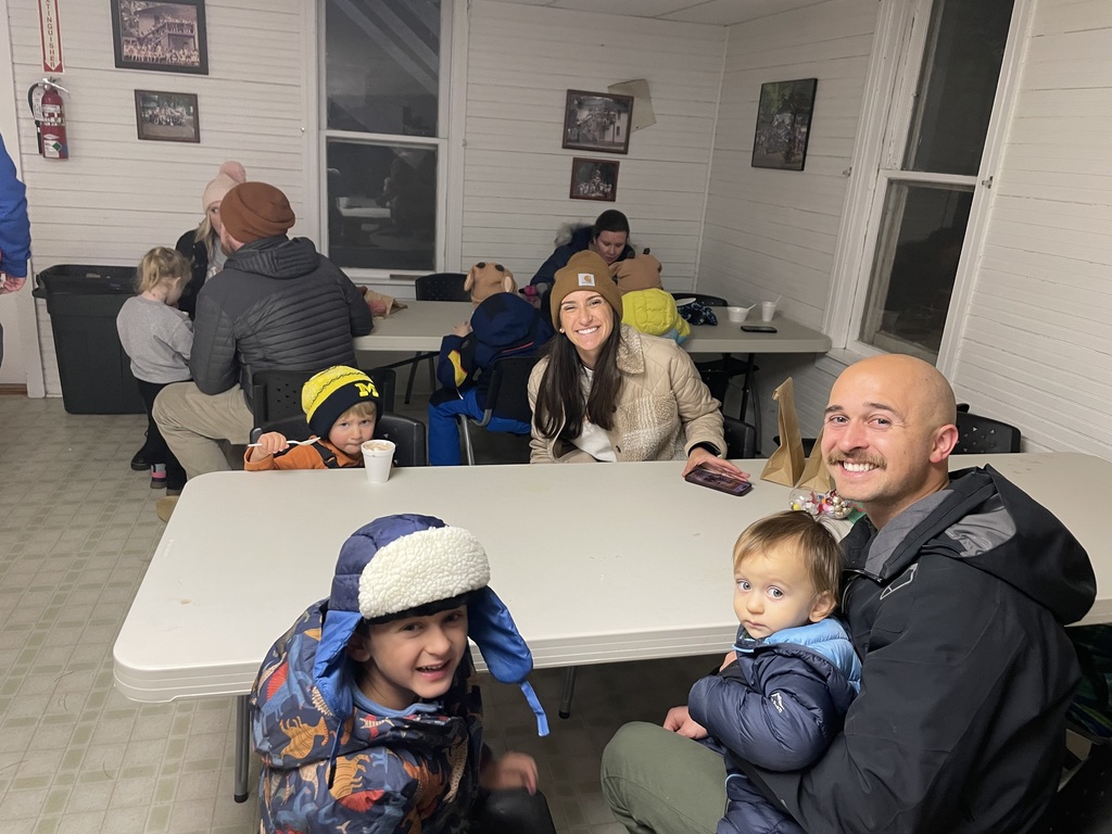 family sits at a table drinking hot chocolate