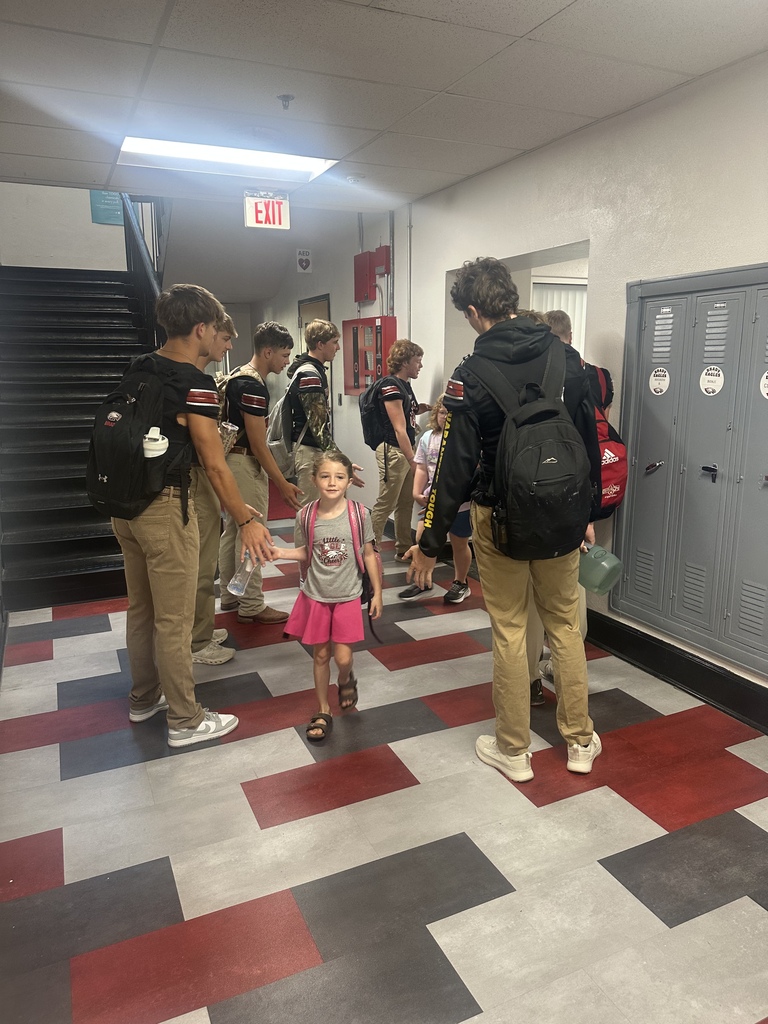football players giving high fives to elementary 