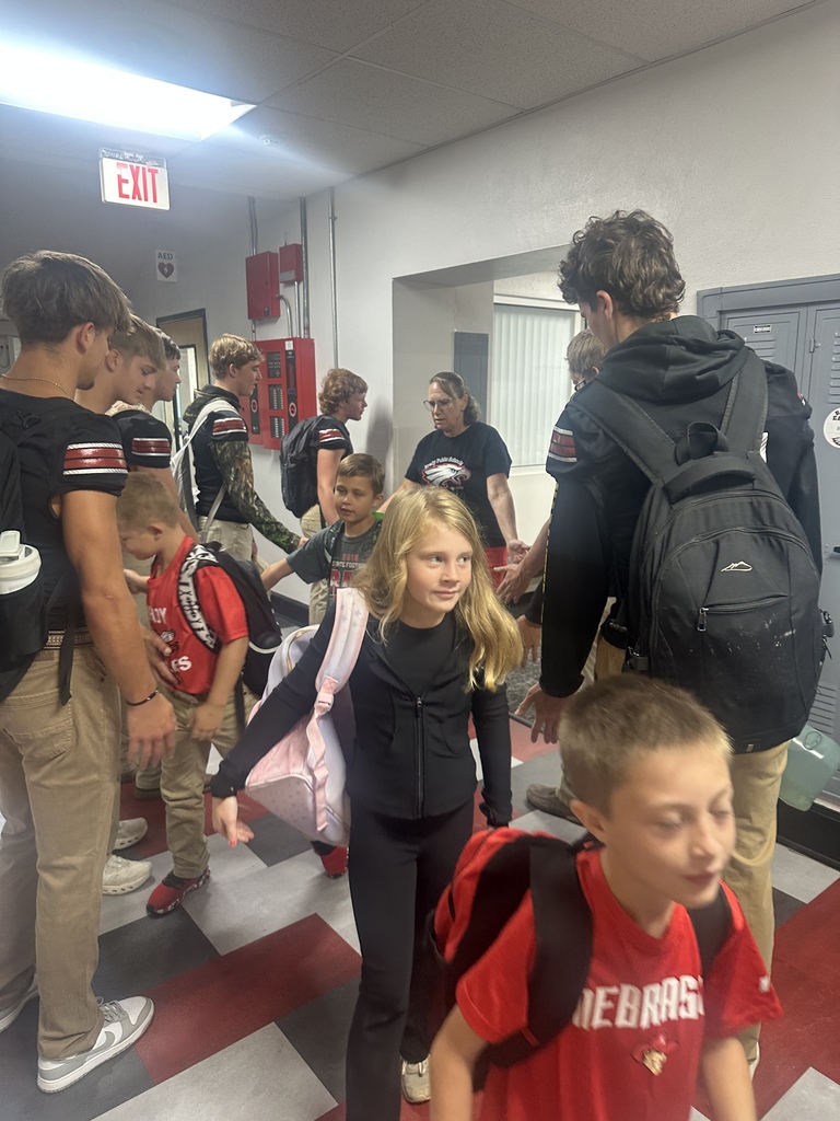 football players giving high fives to elementary 