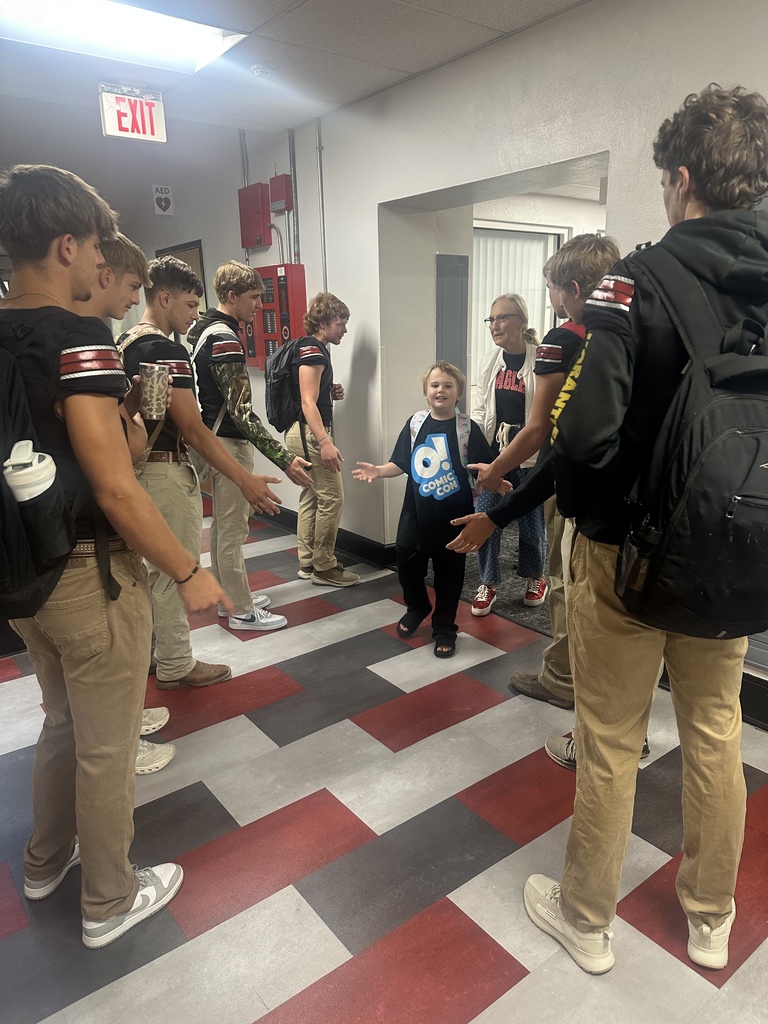 football players giving high fives to elementary 
