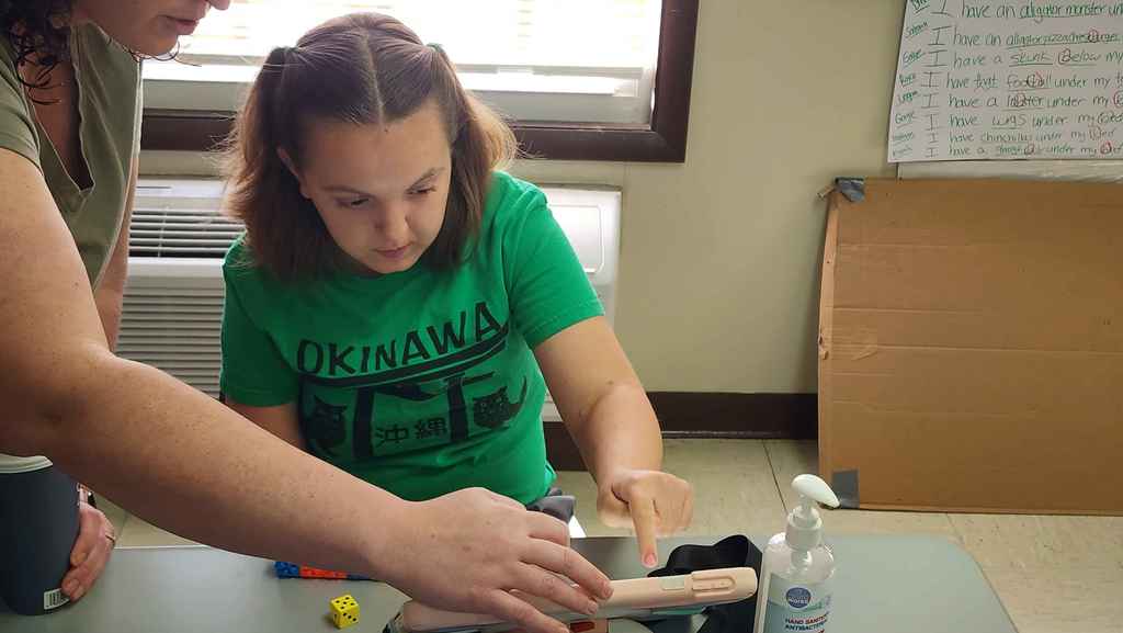 A student and her teacher working on her AAC