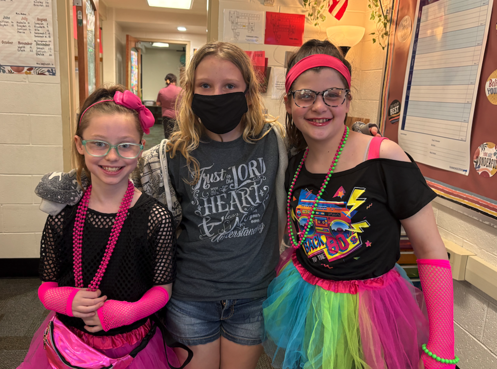 three girls, two dressed up for 80s day
