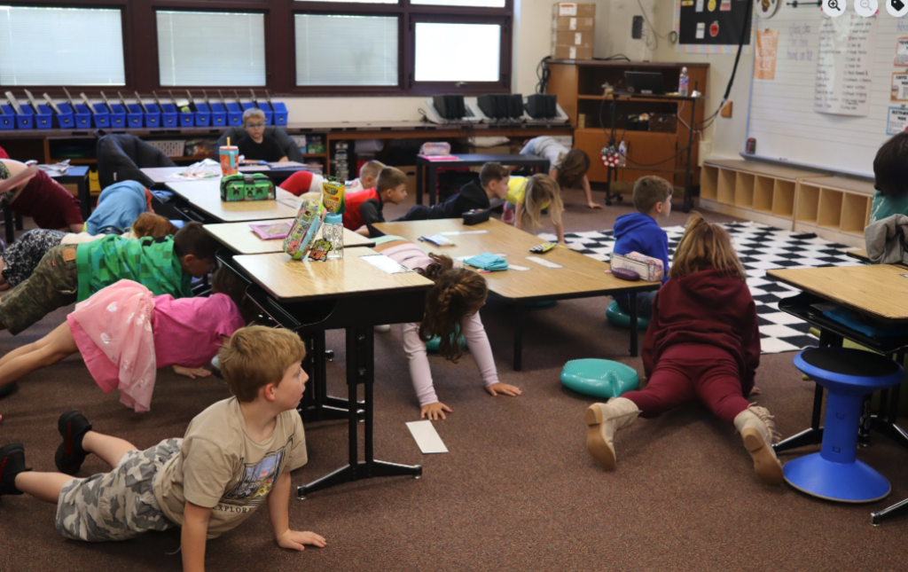 kids doing yoga poses on classroom floor