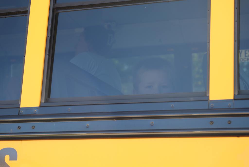 kid looking out bus window