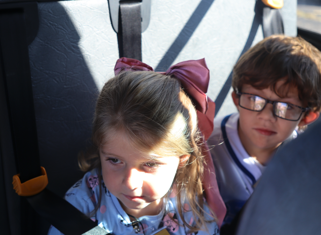 two kids sitting in a bus seat