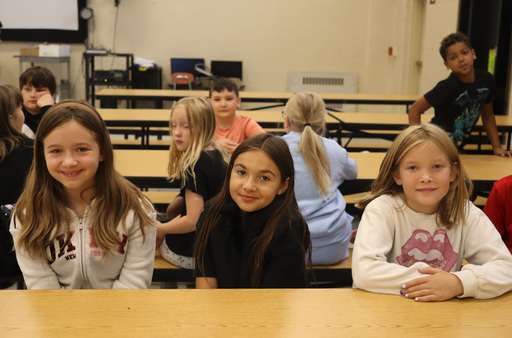 three young girls sitting at the lunch table