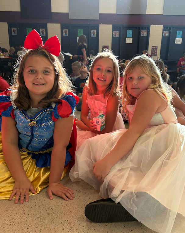three little girls dressed up in princess dresses
