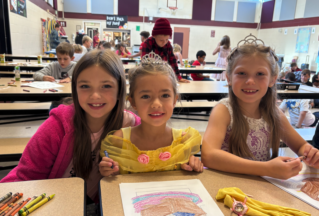 three girls, two in crowns, coloring