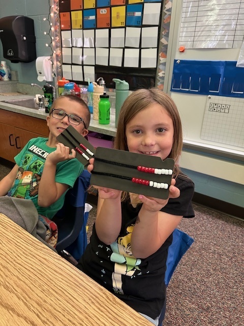 two students holding number racks