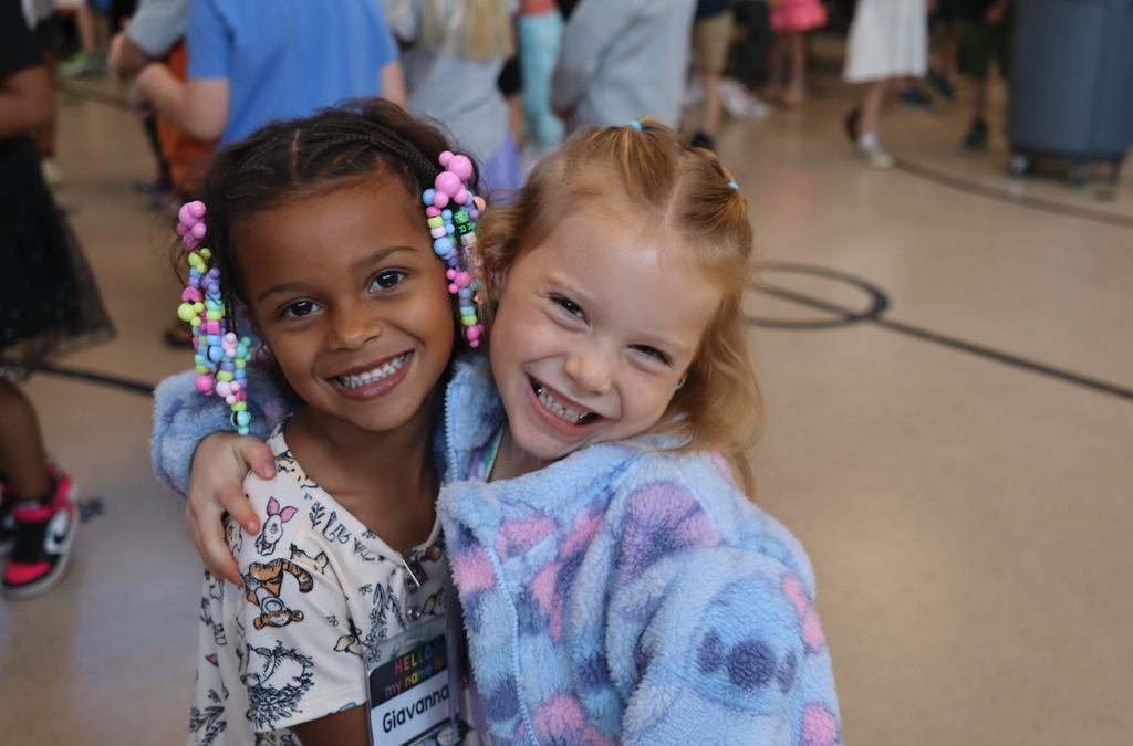 two little girls smiling in the cafeteria