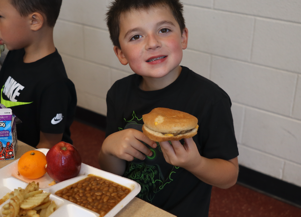 little boy eating a cheeserburger