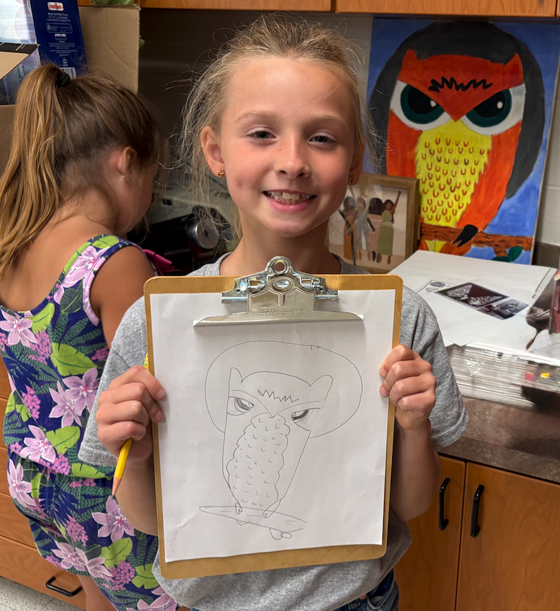 little girl holding up clipboard