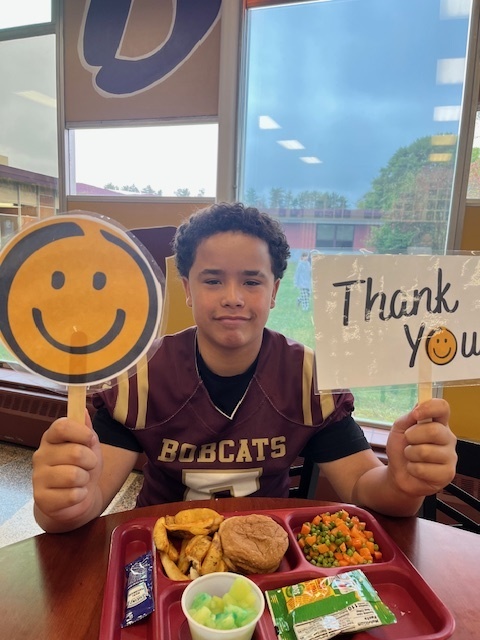 student with thank you sign